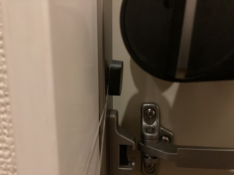 糸で少しづつQrio Lockの開閉センサーを剥がします